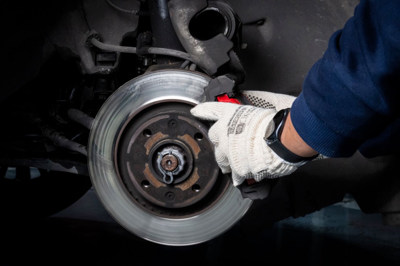 Brake pads and rotors showing wear on a garage workbench