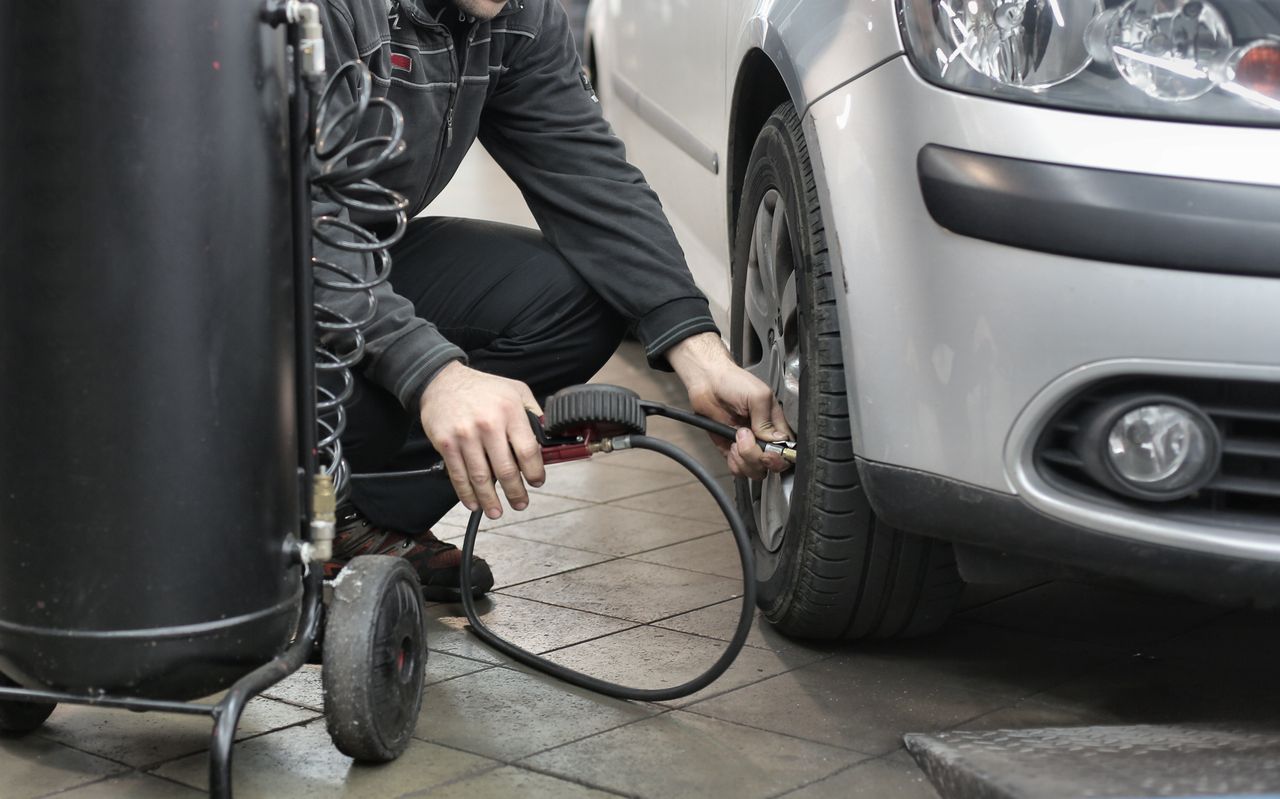 Checking tire pressure with a gauge at Valvoline Xpress Lube