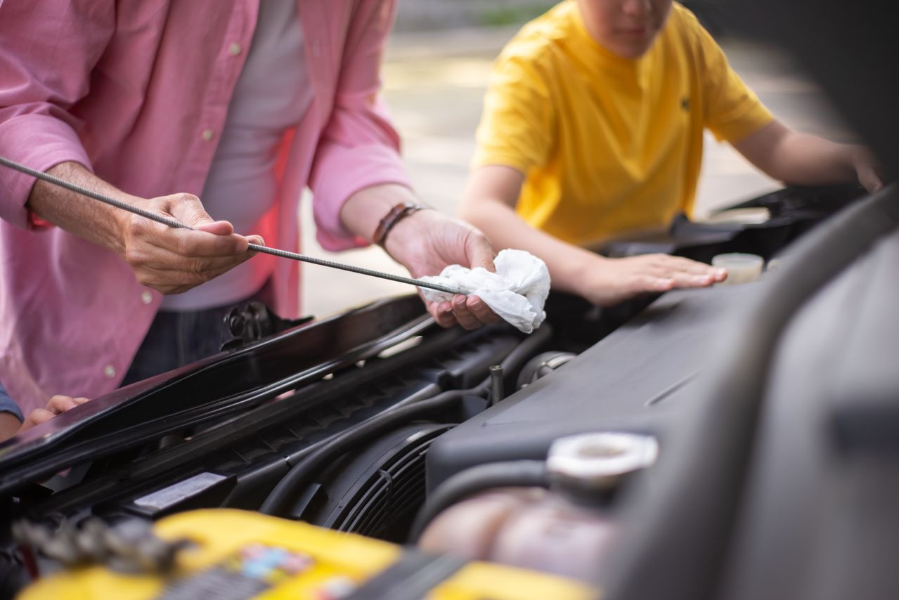 Used motor oil draining from a car showing dark sludge buildup
